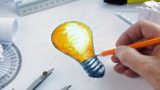 Designer drawing a light bulb, concept for brainstorming